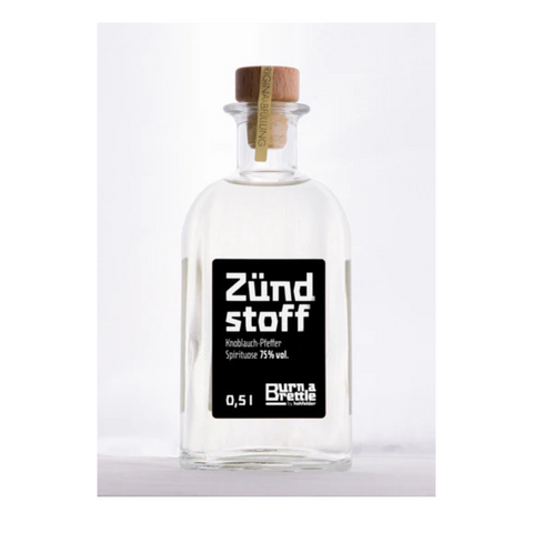 Brettle anzünden Zündstoff: 0,5L Klarglasflasche mit Holzkorken, Aufschrift Zündstoff, enthält 75% Spiritus – ideal zum Anzünden eines Brettle oder zum Genießen in verschiedenen Geschmacksrichtungen.