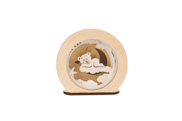 Die Magic Light 3D Holz-Nachtlampe Wolkenbär zeigt einen Bären auf einer Mondsichel, umgeben von Sternen und Wolken, und schafft mit sanfter LED-Technologie eine beruhigende Atmosphäre.