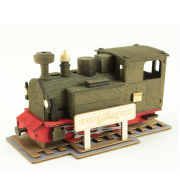 Die Räucherlok Fichtelbergbahn, schwarz ist eine hölzerne Modell-Oldtimerlokomotive mit einem Fichtelbergbahn-Schild auf einem Gleisdisplay und klassischen Brenntechnik-Details, die von traditionellen Räucherloks inspiriert sind.