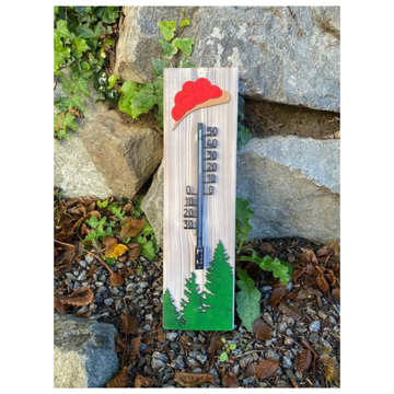Das Schwarzwald-Thermometer besteht aus altem Weymouth-Kiefernholz, bemalten Bäumen und einem roten Hutdesign und fängt den rustikalen Charme und die Anziehungskraft der Natur inmitten von Felsen und Laub ein.
