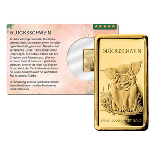 Ein Goldplättchen mit einem lächelnden Glücksschwein-Motiv und dem Schriftzug GLÜCKSSCHWEIN, präsentiert neben einer passenden Karte – ideal für Ihre Goldanlage.