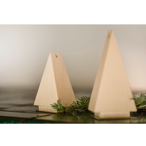 Zwei Räuchermännchen Räuchertanne dreieckiger Baumschmuck aus Fichtenholz mit einem Tannenzweig auf einem Tisch.