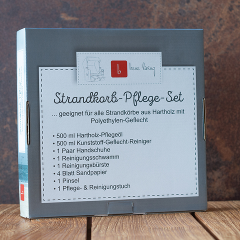 Eine graue Box mit der Aufschrift „Strandkorb Zubehör Pflegeset“, ideal zur Pflege Ihres Strandkorbs, steht auf einer Holzoberfläche mit rustikalem Hintergrund.