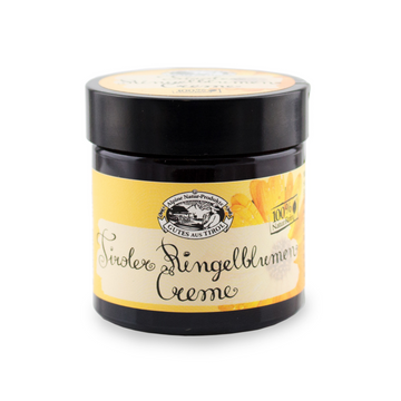 Ein dunkler Tiegel mit der Aufschrift „Ringelblumen Creme“ mit gelbem Etikett und Blumenillustration, ideal für glatte Haut und zur Unterstützung der natürlichen Hautregeneration.