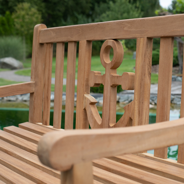 Die Teak-Gartenbank Anker, gefertigt aus massivem Naturholz mit Anker-Design auf der Rückenlehne, eignet sich perfekt als Outdoor-Möbel am Teich in Ihrem Garten für entspannte Momente.