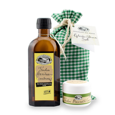 Das Gelenke-Power-Set der Alpine Naturprodukte GmbH beinhaltet eine Flasche, ein kleines Döschen MURMELÖL CREME und einen grün karierten Stoffbeutel mit weißem Etikett, alles zusammengestellt.