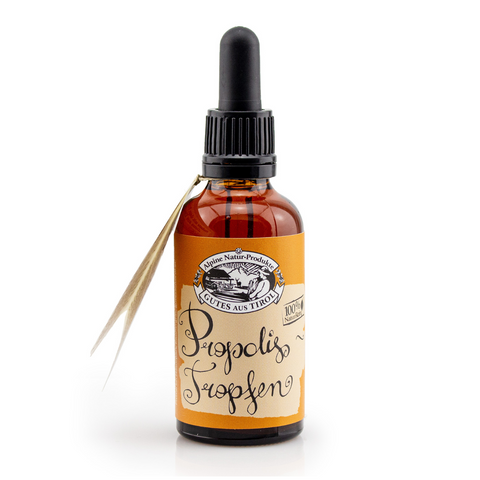 Braune Tropfflasche aus Glas mit der Aufschrift „Propolis Tropfen“ mit dekorativem Etikett und schwarzem Deckel, der die bioaktiven Substanzen aus Bienenwachs hervorhebt.