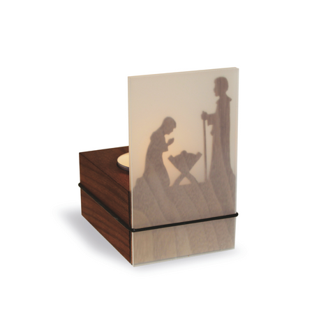 Der Teelichtleuchter Schattenspiel 1er Krippe ist eine kleine Nussbaumholzbox mit einer durchscheinenden Platte, auf der die Silhouette einer Krippe abgebildet ist und die wunderschön von hinten beleuchtet wird, um einen bezaubernden Schattenspieleffekt zu erzielen.