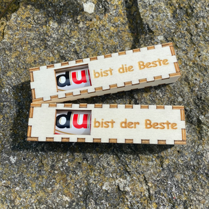 Das Schwarzwald Geschenkboxen 2er Set besteht aus zwei Holzboxen mit deutschem Text, die jeweils einen USB-Stick enthalten und im Freien auf rauem Stein präsentiert werden – eine einzigartige Verpackung, inspiriert vom Schwarzwald.