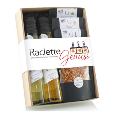 Geschenkbox mit Aufschrift „Raclette-Genuss“ mit Ölen, Dip-Gewürzen, Gewürzen und Würzpaketen für den perfekten Raclette-Genuss.