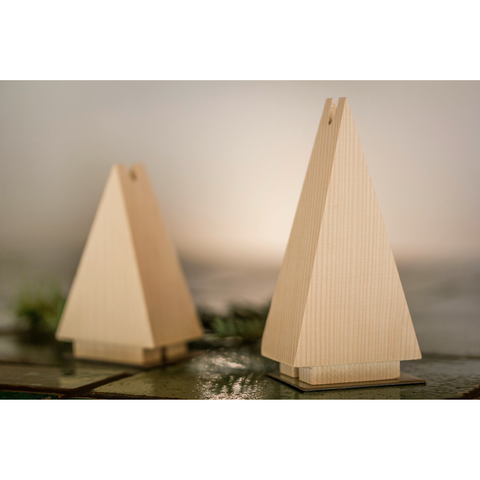 Zwei Räuchermännchen-Räuchertanne-Ornamente, pyramidenförmig und aus Fichtenholz gefertigt, mit kleinen Löchern an der Spitze für Räucherkegel, stehen auf einer reflektierenden Oberfläche.
